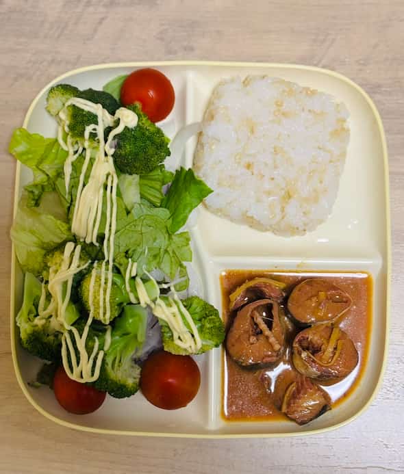 ご飯、魚、野菜が乗った皿